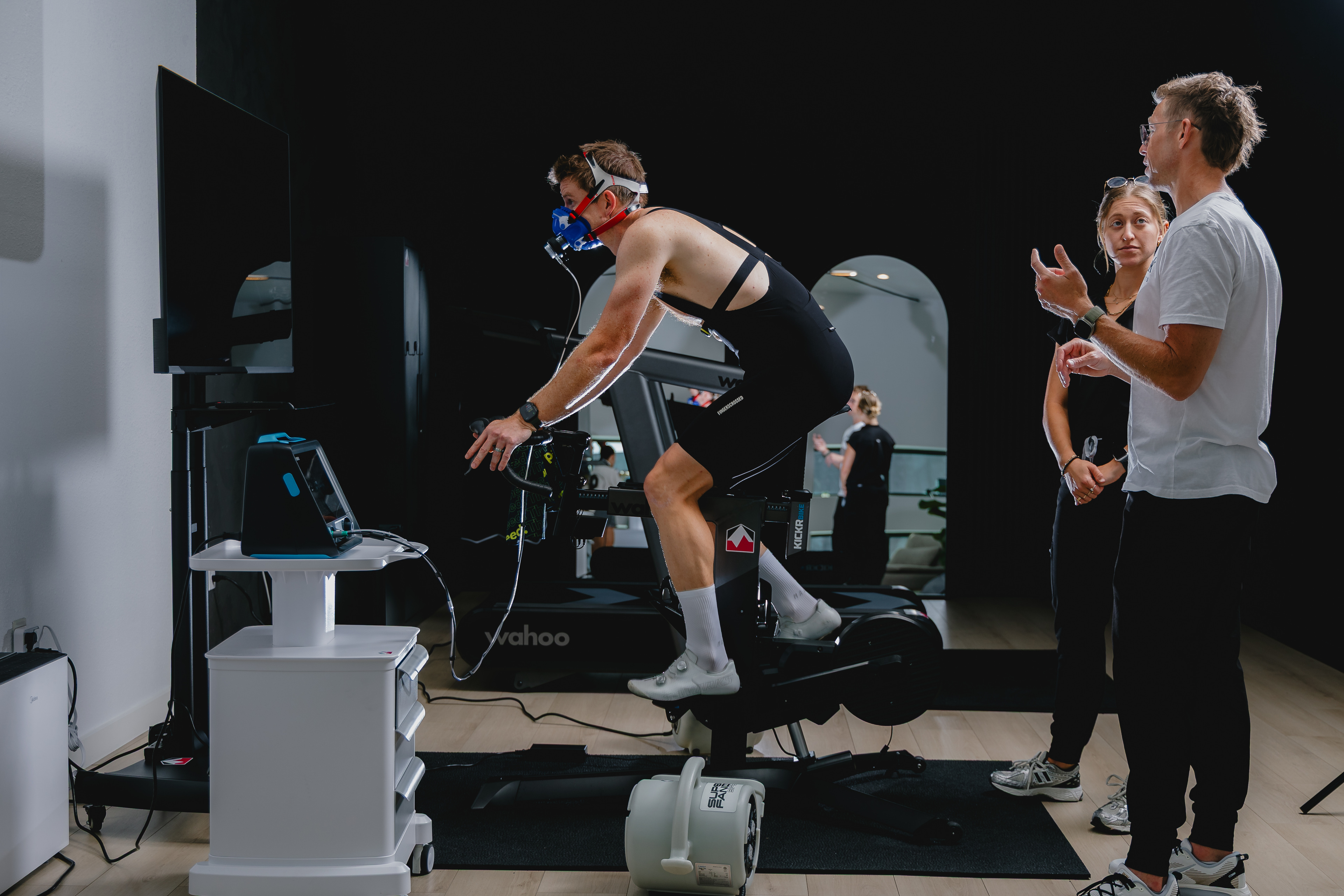 Athlete on a bike with metabolic testing equipment and staff